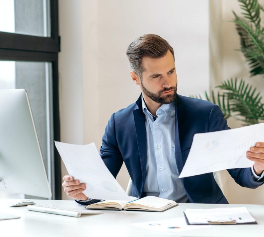 Work with financial documents. Concentrated clever successful caucasian company boss, financial